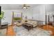 Bright living room with a large window, hardwood floors, ceiling fan, and comfortable seating. Vaulted ceiling above at 7434 Lawyers Station Dr, Mint Hill, NC 28227