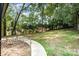 Lush, green backyard with mature trees provides a private, serene outdoor space at 8208 Doverdale Ln, Charlotte, NC 28217