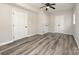 Bright bedroom with modern ceiling fan, neutral walls and sleek, gray wood-look floors at 8208 Doverdale Ln, Charlotte, NC 28217