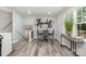 Bright dining area features modern art, and seamless access to the kitchen and staircase at 8208 Doverdale Ln, Charlotte, NC 28217