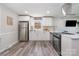 Modern kitchen with white cabinets, stainless steel appliances, and a breakfast bar overlooking the living room at 8208 Doverdale Ln, Charlotte, NC 28217
