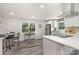 Bright, modern kitchen and dining area featuring white cabinets and a breakfast bar overlooking the dining space at 8208 Doverdale Ln, Charlotte, NC 28217
