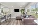 Open-concept living room features a comfortable sectional sofa, hardwood floors, and large windows with natural light at 8208 Doverdale Ln, Charlotte, NC 28217