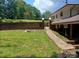 A stone walkway leads to a brick fence and a backyard space with a manicured lawn at 8417 Rolling Hills Ave, Hickory, NC 28602