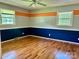 Empty bedroom with hardwood floors, two windows, and unique accent paint at 8417 Rolling Hills Ave, Hickory, NC 28602
