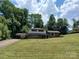 Two-story home with brick accents, large lawn and carport against a backdrop of mature shade trees at 8417 Rolling Hills Ave, Hickory, NC 28602