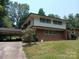 Two-story home featuring a carport, brick accents, and a well-manicured lawn at 8417 Rolling Hills Ave, Hickory, NC 28602