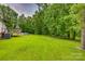 A lush green backyard featuring a wooden deck with pool and a grassy lawn at 10435 Silver Mine Rd, Fort Mill, SC 29707