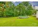A lush green backyard featuring a pool, wooded area and part of the home at 10435 Silver Mine Rd, Fort Mill, SC 29707
