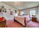 Bright bedroom with pink carpet, chandelier, and natural light from two windows at 10435 Silver Mine Rd, Fort Mill, SC 29707