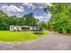 Exterior shot of home with large front yard, mature trees, trampoline, and wooden shed at 10435 Silver Mine Rd, Fort Mill, SC 29707