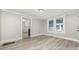 Bright living room features gray walls, white trim, and light vinyl flooring with a glimpse into an adjacent room at 105 Mcgill Nw Ave, Concord, NC 28025