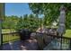 Spacious back deck with an umbrella table, chairs, and grill, overlooking a green yard at 1239 Mac Ln, Stanley, NC 28164