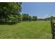 Expansive backyard with green grass, mature trees, and a wooden fence on property at 1239 Mac Ln, Stanley, NC 28164