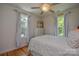 Relaxing bedroom with natural light, white comforter, and hardwood flooring at 1239 Mac Ln, Stanley, NC 28164