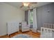 Bedroom with a changing table, rocker, and alphabet rug over wood flooring at 1239 Mac Ln, Stanley, NC 28164
