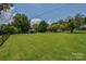 Expansive grassy yard with mature trees and a shed, offering plenty of space and a natural setting at 1239 Mac Ln, Stanley, NC 28164