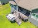 Aerial view of a house featuring a multi-level deck with dining and living furniture and a backyard at 1320 Torrens Dr, Wesley Chapel, NC 28110