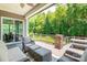 Covered deck with wicker furniture, rug, fan, sliding door and a view of a wooded backyard at 1320 Torrens Dr, Wesley Chapel, NC 28110