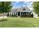 Charming home with gray siding, stone accents, manicured lawn, and inviting front porch at 1320 Torrens Dr, Wesley Chapel, NC 28110