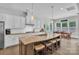 Large kitchen features an island with seating, stainless appliances, and dining area at 1320 Torrens Dr, Wesley Chapel, NC 28110
