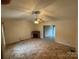This living room includes a ceiling fan, window, and decorative fireplace at 1519 Midland Dr, Hudson, NC 28658