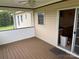 Exterior view of an enclosed screened porch featuring wood flooring and an entry door at 1519 Midland Dr, Hudson, NC 28658