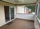 Enclosed screened porch with wood flooring and views of the yard and nearby houses at 1519 Midland Dr, Hudson, NC 28658