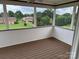 Inviting screened porch with dark wood flooring and views of the surrounding yard and neighborhood at 1519 Midland Dr, Hudson, NC 28658