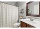 Modern bathroom featuring a new shower curtain, decorative shelves and a wood-framed mirror at 1800 Robbins Meadows Dr, Waxhaw, NC 28173