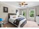 Well-lit bedroom with a ceiling fan and two windows with views of nature at 1800 Robbins Meadows Dr, Waxhaw, NC 28173