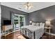 Comfortable bedroom boasts dark gray walls, hardwood floors, and a view of the backyard at 1800 Robbins Meadows Dr, Waxhaw, NC 28173