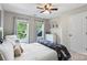 Neutral bedroom featuring a ceiling fan, a large window, and a comfortable bed at 1800 Robbins Meadows Dr, Waxhaw, NC 28173