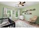Bright Bedroom features two windows, light green walls, ceiling fan, rocker, and stylish geometric area rug at 1800 Robbins Meadows Dr, Waxhaw, NC 28173