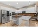 Modern kitchen features a granite-topped island with seating, stainless appliances, and updated white cabinets at 1800 Robbins Meadows Dr, Waxhaw, NC 28173