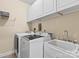 Functional laundry room featuring a utility sink and ample cabinet space above washer/dryer at 1800 Robbins Meadows Dr, Waxhaw, NC 28173