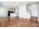 Open-concept living space with hardwood floors leading to the kitchen and staircase at 198 Devon Forest Dr, Mooresville, NC 28115