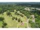 Aerial view of a golf course with tree-lined fairways and residential homes, offering a scenic view at 2104 Stoneyridge Dr, Charlotte, NC 28214