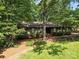 One story home surrounded by mature trees, featuring a well-maintained lawn at 2104 Stoneyridge Dr, Charlotte, NC 28214