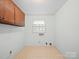 Functional laundry room features upper cabinets and natural light at 2104 Stoneyridge Dr, Charlotte, NC 28214