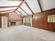 Vaulted living room boasts wood accents, a brick fireplace, and natural light from large windows at 2104 Stoneyridge Dr, Charlotte, NC 28214