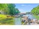 Wooden dock on the lake with a boat and several boat slips surrounded by dense woods at 2116 Bon Villa Way, Fort Mill, SC 29708