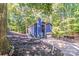 Exterior view of a blue two-story home with a garage surrounded by lush greenery and a long drive way at 2116 Bon Villa Way, Fort Mill, SC 29708