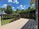 Well-maintained wooden deck surrounded by lush greenery and a blue sky, ideal for outdoor relaxation at 228 31St Avenue Ne Ct, Hickory, NC 28601