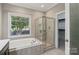 Bright bathroom featuring a soaking tub, walk-in shower and large window that offers ample natural light at 2411 Stoney Run Dr # 13, Oakboro, NC 28129