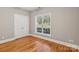 Bedroom featuring hardwood floors, a window with blinds, and a spacious closet at 2411 Stoney Run Dr # 13, Oakboro, NC 28129