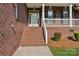 Inviting front porch with brick stairs, white railings, and a view of the entry door at 2411 Stoney Run Dr # 13, Oakboro, NC 28129