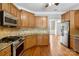 The kitchen showcases wood cabinets, granite counters, stainless steel appliances, and hardwood floors at 2411 Stoney Run Dr # 13, Oakboro, NC 28129