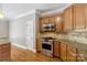 Galley kitchen with stainless steel oven, granite countertops, tile backsplash and wood cabinets at 2411 Stoney Run Dr # 13, Oakboro, NC 28129