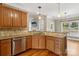 Well-lit kitchen featuring stainless steel dishwasher, granite countertops, wood cabinets and hardwood floors at 2411 Stoney Run Dr # 13, Oakboro, NC 28129